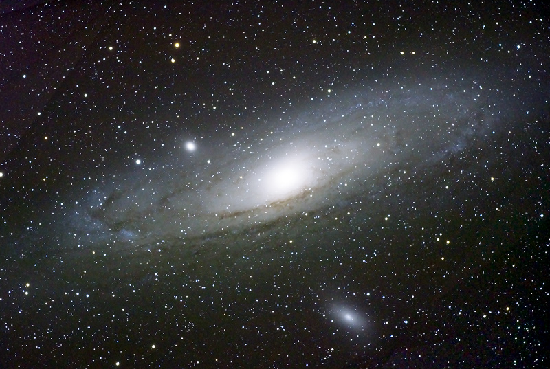 Andromeda galaxia (M31), Esne Bidetik hurbilen dagoen galaxia erraldoia; 1,23 <font face="Symbol">×</font> <span>10</span><span style="font-size:58%;vertical-align:super">12</span> eguzki-masakoa da (materia iluna ere kontuan hartuz), eta 778.000 parseceko distantziara dago. Irudian, M31 galaxiaren diskoaren gainean eta azpian, M32 eta M110 galaxia nano sateliteak ageri dira