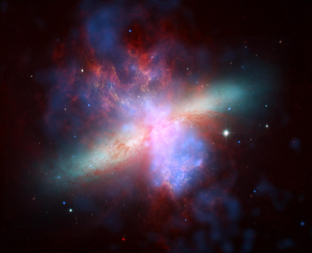 M82 galaxia. NASAren <span style="font-style:italic">Spitzer</span>, <span style="font-style:italic">Hubble</span> eta <span style="font-style:italic">Chandra</span> espazio-behatokien emaitza bateratua, espektroaren hainbat esparrutako irudiekin eginiko konposaketa, kolore faltsutan